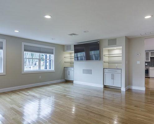 Large hardwood floor living room area with large tv and great lighting