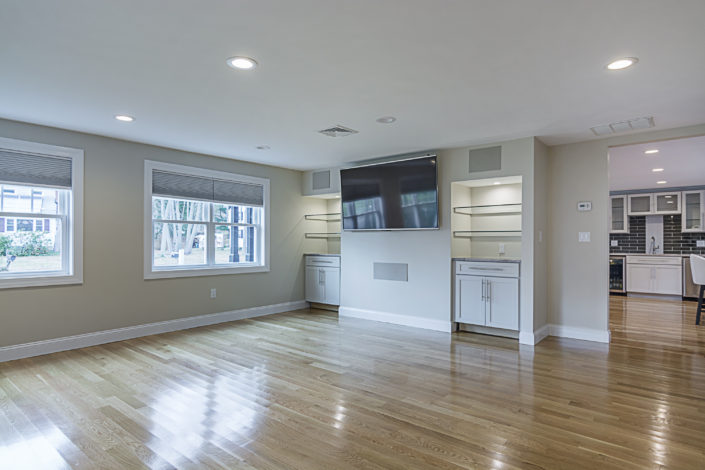 Large hardwood floor living room area with large tv and great lighting